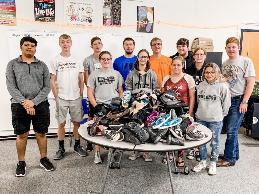 Some+of+our+CHS+National+Honor+Society+members+pose+with+the+nearly+100+pairs+of+shoes+that+our+students+and+community+donated+to+the+SCARS+Foundation.